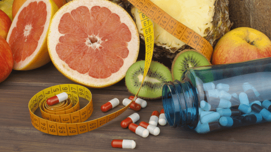 Fruits, a measuring tape, and weight loss pills